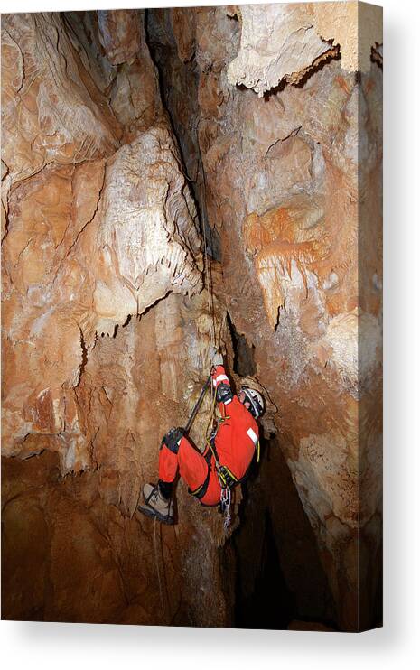 Man Canvas Print featuring the photograph Side View Of Man Climbing On Rock Formations In Cave by Cavan Images