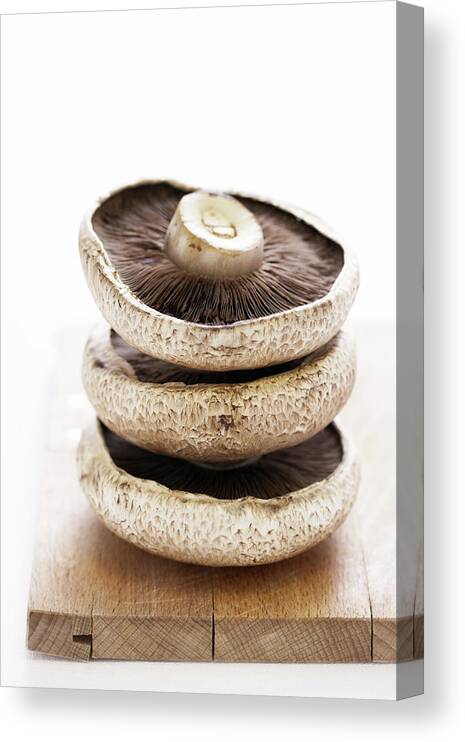 White Background Canvas Print featuring the photograph Three Flat Mushrooms In Pile On Wooden by Martin Poole