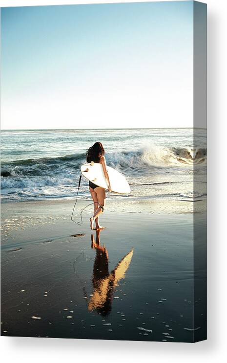 Woman Canvas Print featuring the photograph Woman With Surfboard Walking On Shore At Beach by Cavan Images