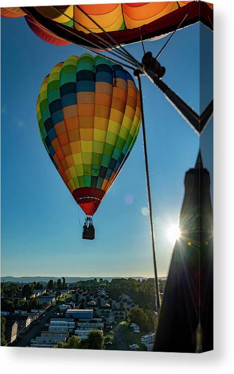 Hot Air Balloon Canvas Print featuring the photograph Flying hot air balloon with sunburst by Dan Friend