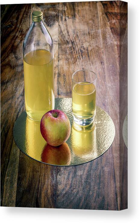 Drinking Glass Canvas Print featuring the photograph Fresh apple juice and red apple on a rustic wooden table by Benoit Bruchez