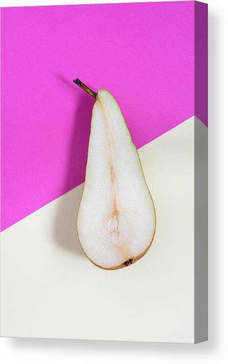 Still-life Canvas Print featuring the photograph Slice of healthy pear fruit on a colourful background. by Michalakis Ppalis
