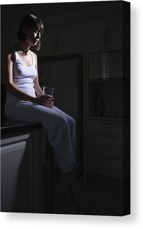 Shadow Canvas Print featuring the photograph Teenage girl sitting on kitchen counter by Image Source