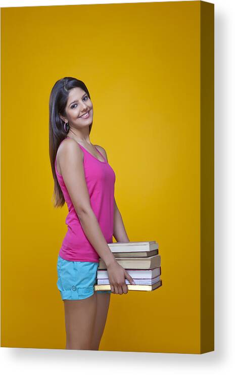 Three Quarter Length Canvas Print featuring the photograph Young woman carrying a pile of books by Ravi Ranjan