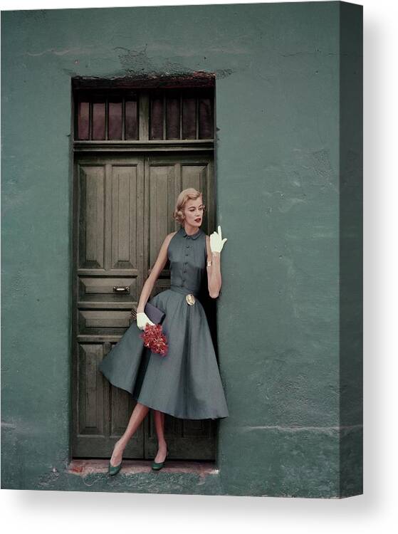 Fashion Canvas Print featuring the photograph A 1950s Model Standing In A Doorway by Leombruno-Bodi