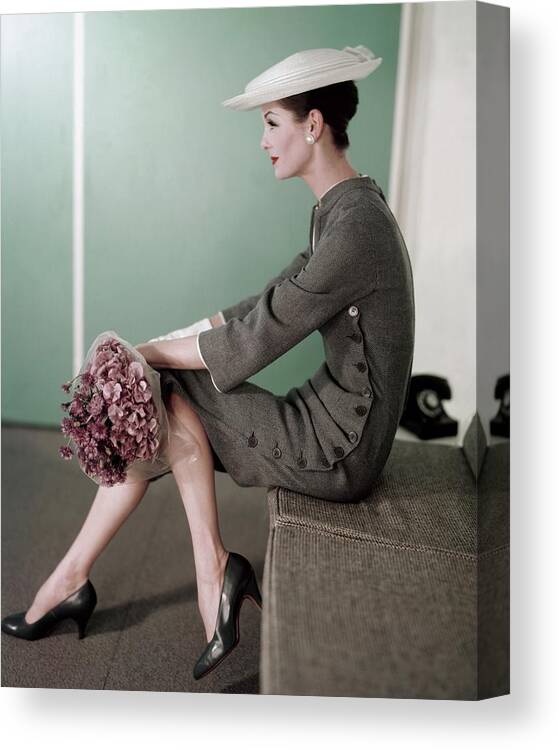 Fashion Canvas Print featuring the photograph A Model Sitting Down With A Bouquet Of Flowers by Karen Radkai