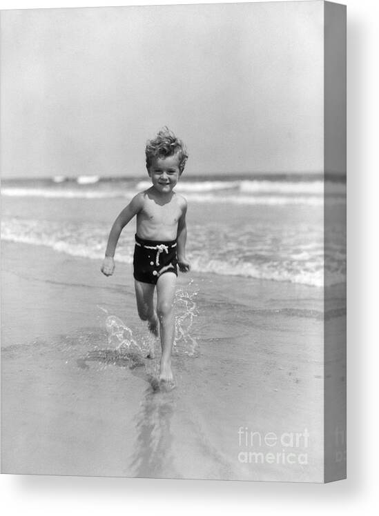 1930s Canvas Print featuring the photograph Smiling Little Boy Running In Surf by H. Armstrong Roberts/ClassicStock