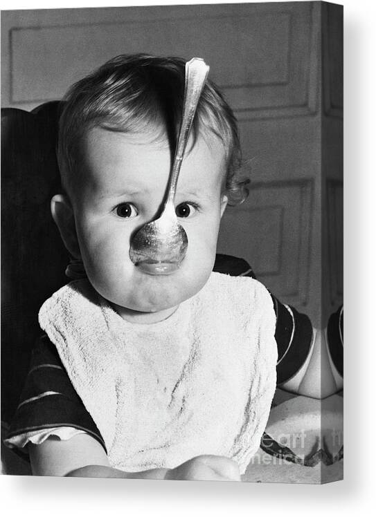 Child Canvas Print featuring the photograph Baby With Spoon In Mouth by Bettmann