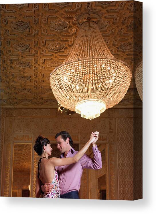Heterosexual Couple Canvas Print featuring the photograph Couple Dancing Beneath Chandelier, Low by Justin Pumfrey