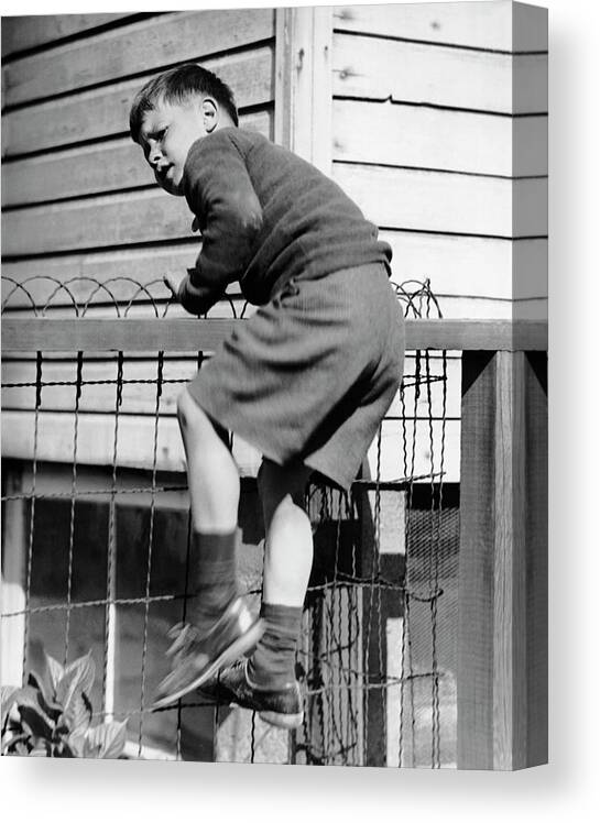 Child Canvas Print featuring the photograph Young Boy Climbing Fence by George Marks