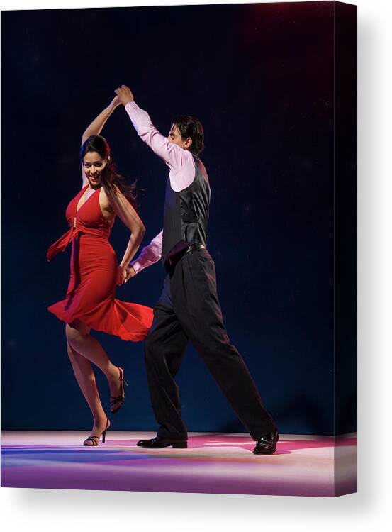 Young Men Canvas Print featuring the photograph Young Couple Swing Dancing Indoors by Pm Images