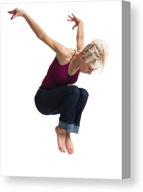 Human Arm Canvas Print featuring the photograph A Young Caucasian Blonde Female In Jeans And A Purple Tank Top Leaps Into The Air And Throws Her Arms Up Behind Her by Photodisc