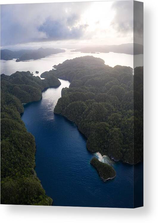 Landscapeaerial Canvas Print featuring the photograph A Narrow, Coral-filled Channel Runs by Ethan Daniels