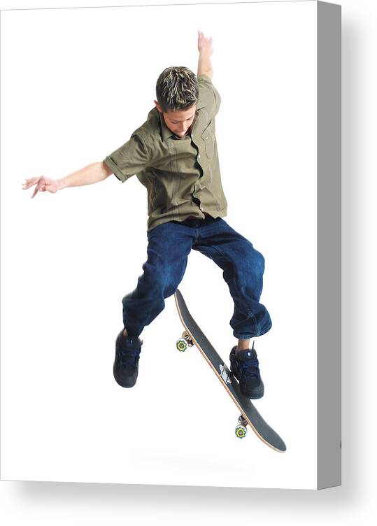 Recreational Pursuit Canvas Print featuring the photograph A Young Caucasian Boy Does Tricks On His Skateboard by Photodisc
