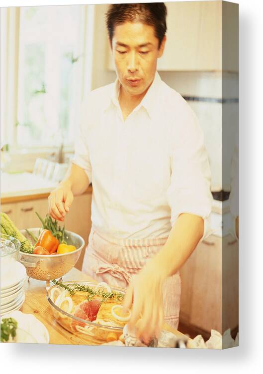 People Canvas Print featuring the photograph Man in kitchen preparing food by Dex Image
