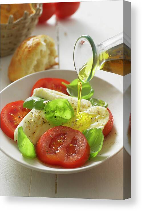 Caprese Salad Canvas Print featuring the photograph Olive Oil Pouring On Caprese Salad In by Westend61
