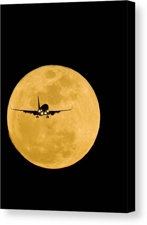 Moon Canvas Print featuring the photograph Aeroplane Silhouetted Against A Full Moon by David Nunuk