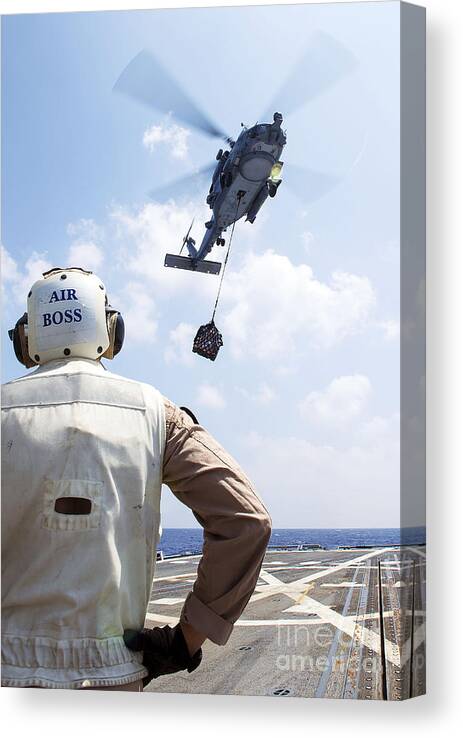 Uss Gravely Canvas Print featuring the photograph A Sh-60 R Seahawk Prepares To Drop by Stocktrek Images