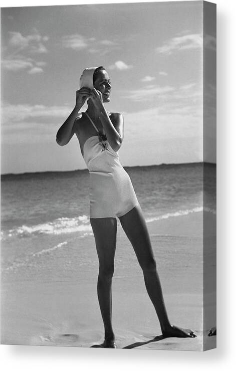 Accessories Canvas Print featuring the photograph Model on a Beach Fastening Her Bathing Cap by Toni Frissell