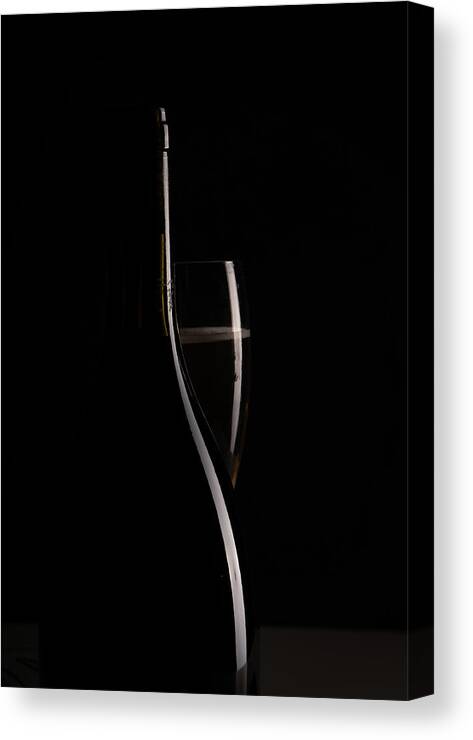 Red Wine Canvas Print featuring the photograph Red sparking wine on a wineglass and black wine bottle. by Michalakis Ppalis