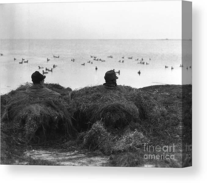 1930s Canvas Print featuring the photograph Two Men Camouflaged In Duck Blind by H. Armstrong Roberts/ClassicStock