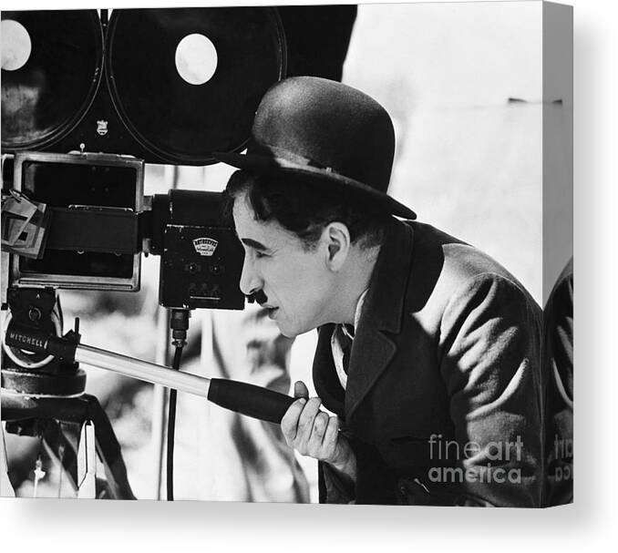 Charlie Chaplin Canvas Print featuring the photograph Charlie Chaplin Behind Movie Camera by Bettmann