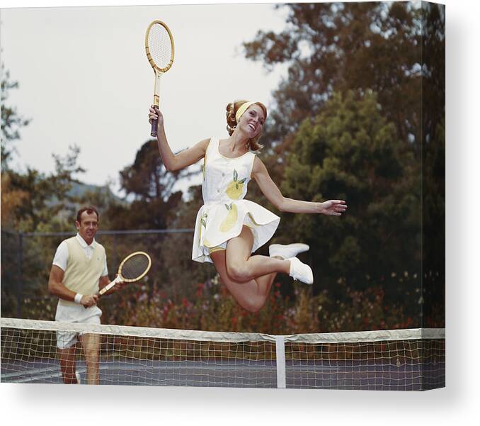 Heterosexual Couple Canvas Print featuring the photograph Couple On Tennis Court, Woman Jumping by Tom Kelley Archive