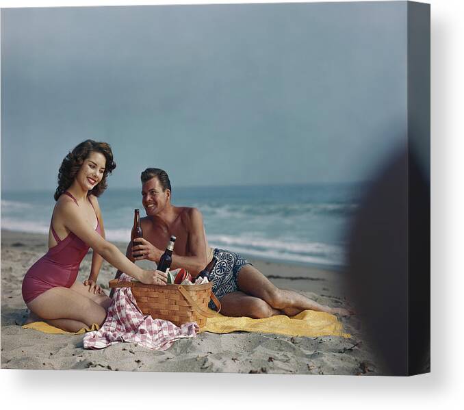 Heterosexual Couple Canvas Print featuring the photograph Couple Sitting On Beach Holding Beer by Tom Kelley Archive