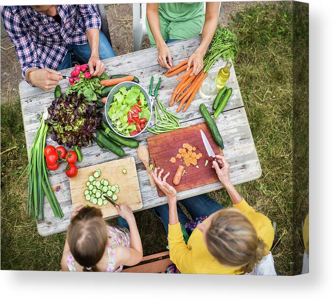 Orange Color Canvas Print featuring the photograph Family Preparing Salad In Garden by Hinterhaus Productions