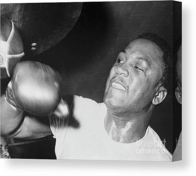 Joe Frazier Canvas Print featuring the photograph Joe Frazier Working Out With Punching by Bettmann