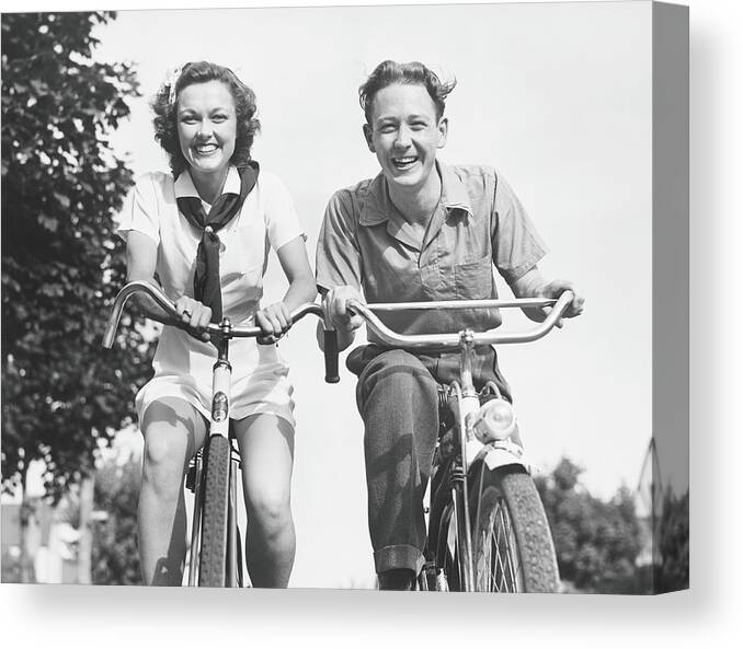 Young Men Canvas Print featuring the photograph Man And Woman Riding Bikes, B&w, Low by George Marks