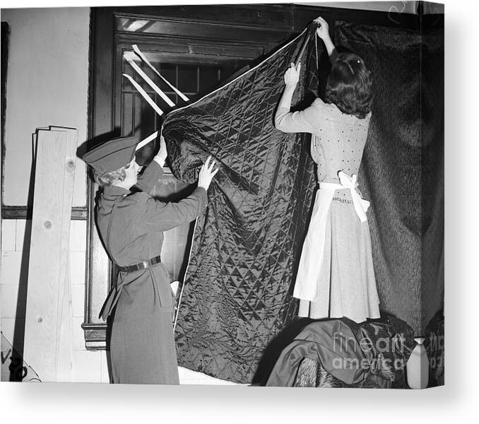 Hanging Canvas Print featuring the photograph Women Blacking Out Windows With Blanket by Bettmann