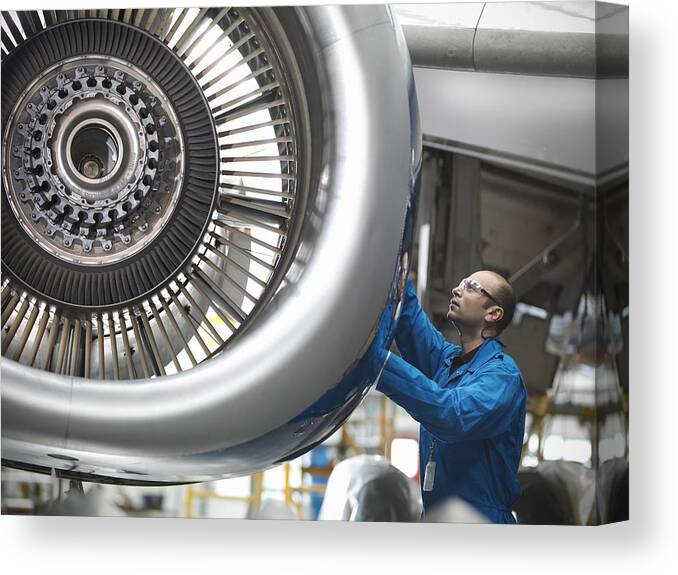 Expertise Canvas Print featuring the photograph Aircraft engineer working on 737 jet engine in airport by Monty Rakusen