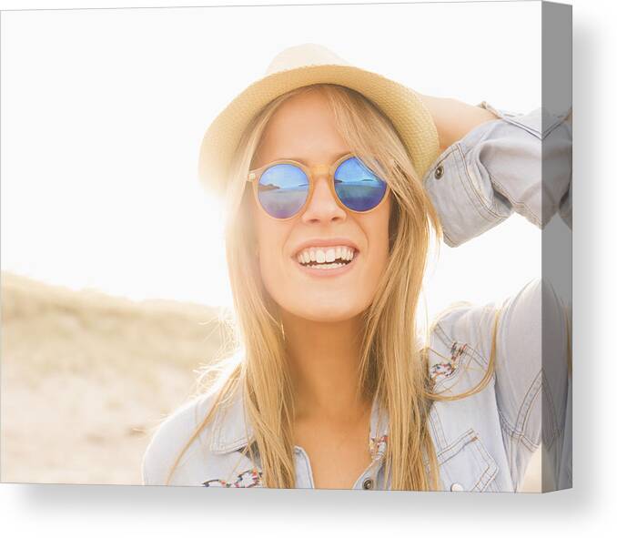 People Canvas Print featuring the photograph Caucasian woman wearing hat and sunglasses on beach by Jacobs Stock Photography Ltd