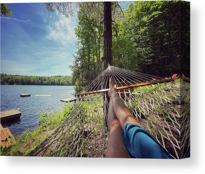 Legs Canvas Print featuring the photograph Female Legs In The End Of A Hammock With A View Of Docks On A Lake. by Cavan Images