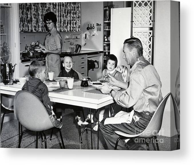 Breakfast Canvas Print featuring the photograph Young Family Eating Breakfast In Kitchen by Bettmann