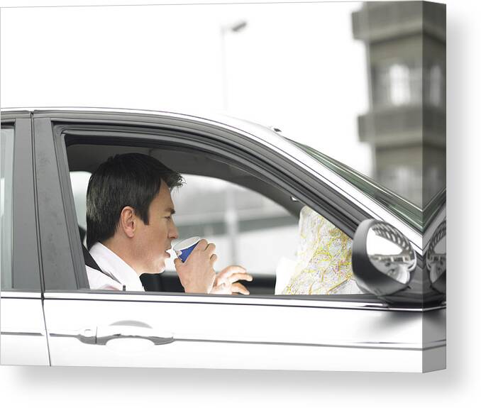 Car Interior Canvas Print featuring the photograph Businessman Drinking a Cup of Coffee Sitting in His Car and Looking at a Map by Digital Vision.