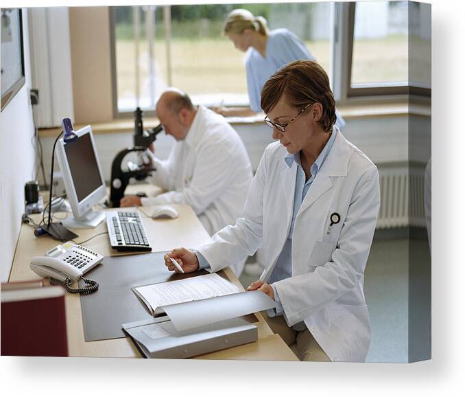 Expertise Canvas Print featuring the photograph Female doctor sitting in office, portrait by Jochen Sands
