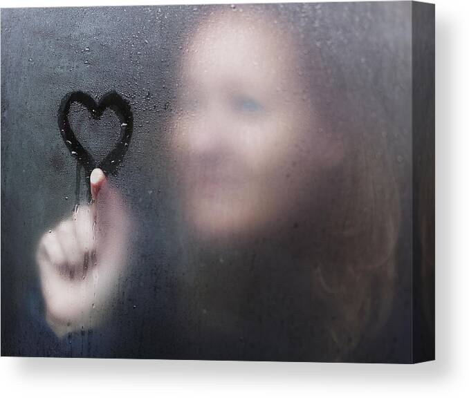 Copenhagen Canvas Print featuring the photograph Woman drawing a heart on window on a rainy day. by David Trood