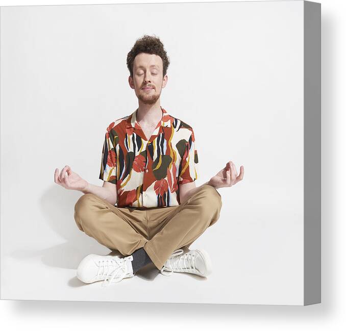 Young Men Canvas Print featuring the photograph Young man sitting in mediation pose by We Are