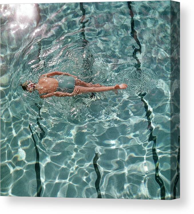 Water Canvas Print featuring the photograph A Woman Swimming In A Pool by Fred Lyon