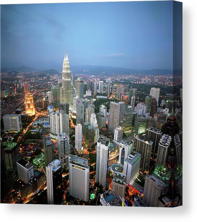 Downtown District Canvas Print featuring the photograph Malaysia, Kuala Lumpur Skyline At Dusk by Martin Puddy
