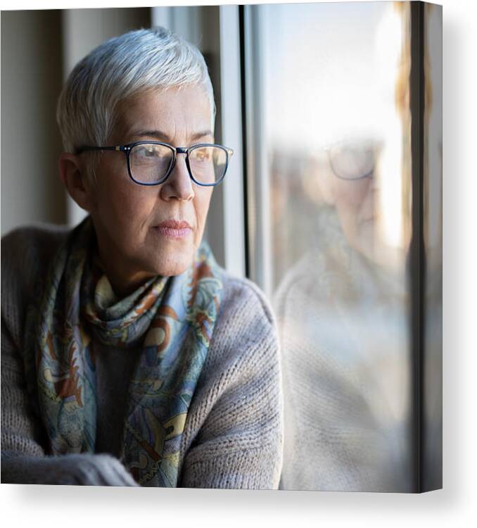 Mature Adult Canvas Print featuring the photograph Portrait of beautiful mature woman relaxing by the window by Mdphoto16