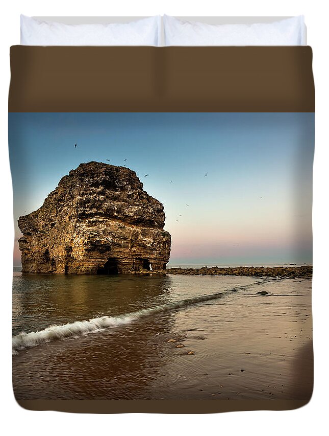 Flying Duvet Cover featuring the photograph A Large Rock Formation On The Coast by John Short