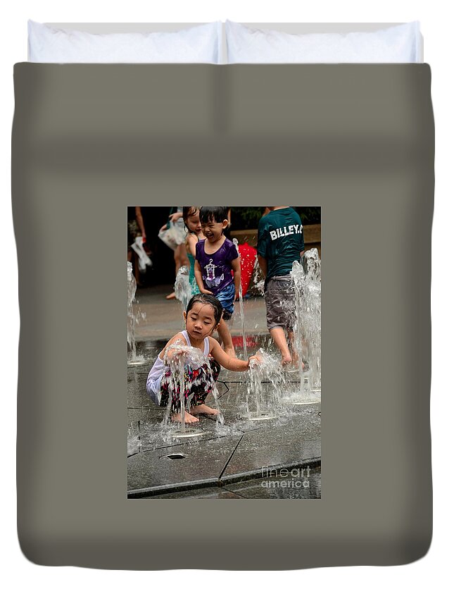 Girl Duvet Cover featuring the photograph Clothed children play at water fountain by Imran Ahmed