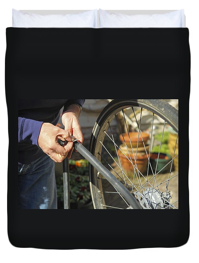 Aged Duvet Cover featuring the photograph Fixing flat bike tire by Patricia Hofmeester