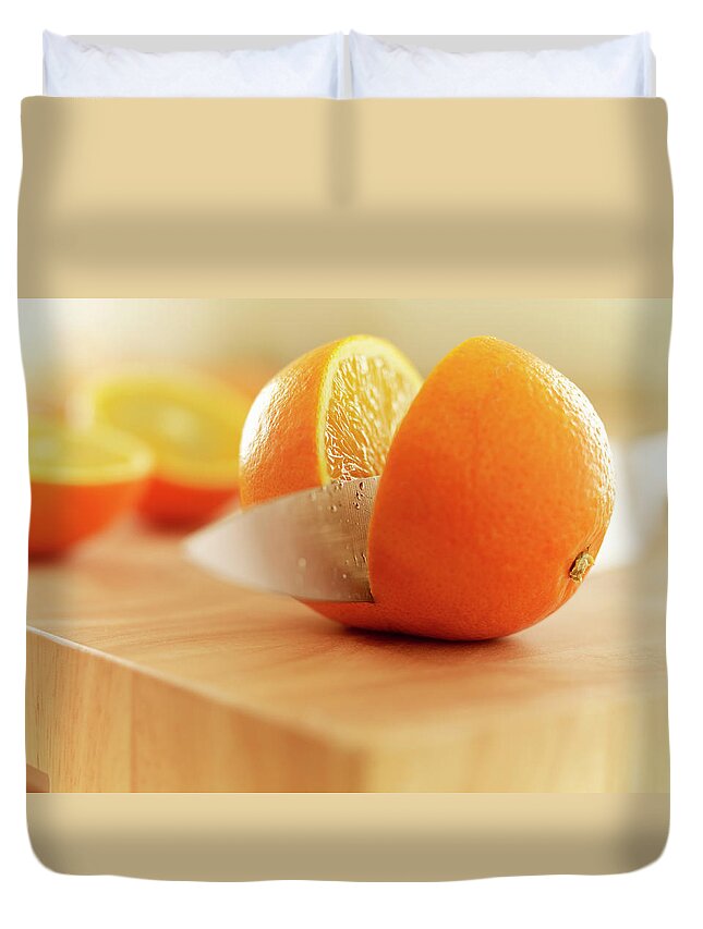 Food And Drink Duvet Cover featuring the photograph Knife Slicing Orange On Cutting Board by Adam Gault