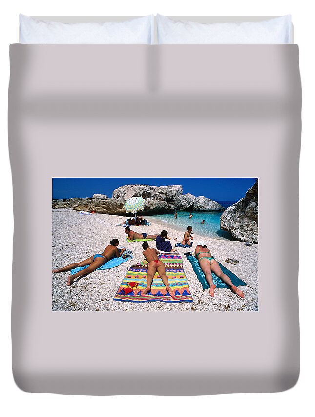 Recreational Pursuit Duvet Cover featuring the photograph People Sunbathing On The Beach At Cala by Dallas Stribley