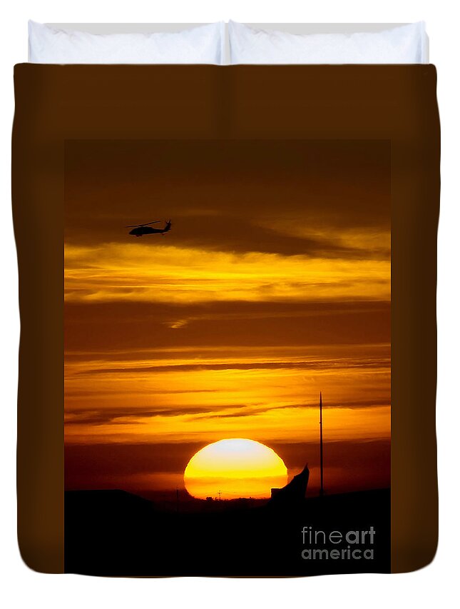 Military Duvet Cover featuring the photograph A Uh-60 Black Hawk Helicopter Flies by Stocktrek Images