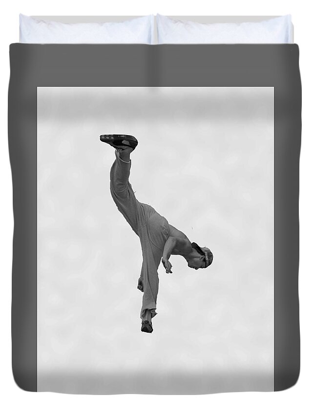 Shirtless Man With Baseball Cap Doing Gymnastics In A Softly Clouded Background. Duvet Cover featuring the photograph Jumping Man by Matthew Bamberg